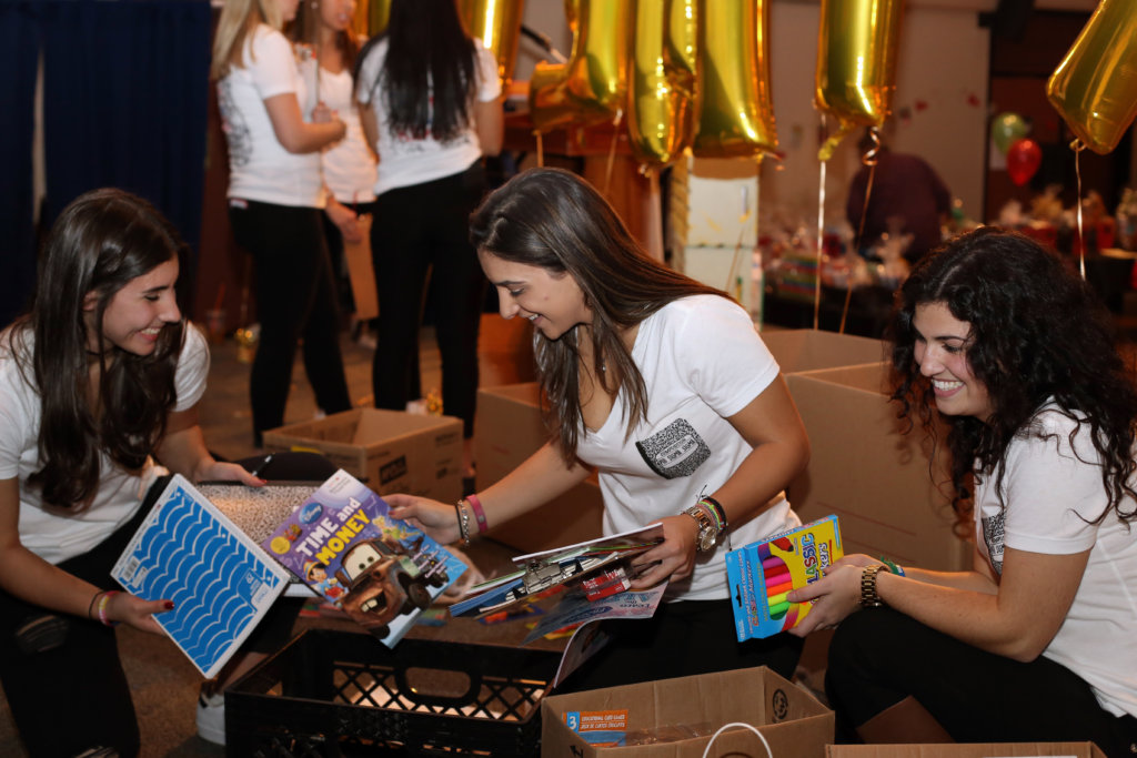 adelphi-university-phi-sigma-sigma-members-sort-donated-books-paula-spatz-athina-mihaliadis-olivia-di-giulio